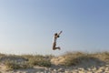 Portrait of a young beautiful woman jumping at the beach at suns Royalty Free Stock Photo