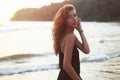 Portrait of a young beautiful woman with long curly hair at the seaside