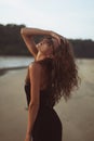 Portrait of a young beautiful woman with long curly hair at the seaside