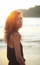 Portrait of a young beautiful woman with long curly hair at the seaside