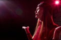 Portrait of a young beautiful woman in with long hair in a Tatar red hat and a red sweater. Fashion photo shoot in low key