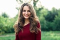 Portrait of young beautiful woman outdoors on green summer nature background