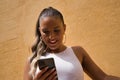 Portrait of young beautiful woman, with pigtails, wearing a white top, checking social networks on her cell phone. Concept beauty Royalty Free Stock Photo