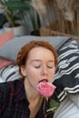 portrait of a young beautiful woman with red hair in the studio with a rose near her face Royalty Free Stock Photo