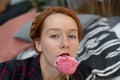 portrait of a young beautiful woman with red hair in the studio with a rose near her face Royalty Free Stock Photo