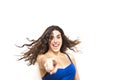 Portrait of young beautiful woman shaking her hair and pointing