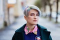 Portrait of a young beautiful woman with a short haircut and dyed hair. Grey main color and yellow, green, blue and red Royalty Free Stock Photo