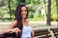 Portrait of young beautiful woman sitting on bench in the public park Royalty Free Stock Photo