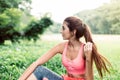 Portrait of young beautiful woman sitting after break workout at park,Happy and smiling,Relaxing time