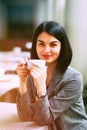 Portrait of young beautiful woman sitting in a cafe outdoor drinking coffee Royalty Free Stock Photo