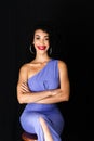 Portrait of young beautiful woman, smiling, sitting on a stool. with arms crossed Royalty Free Stock Photo