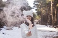 Portrait of a young beautiful woman in the snow holding a yellow bomb smoke. Sunny weather. Wearing warm clothes. Winter lifestyle Royalty Free Stock Photo