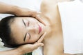 Beautiful young woman lying with closed eyes and having face and head massage at spa Royalty Free Stock Photo
