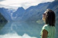 Portrait of young, beautiful woman standing near by mountain lake in Norway. Royalty Free Stock Photo