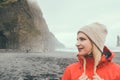 Portrait of young beautiful woman standing near the troll toes on the beach in Iceland and looking sideways. Royalty Free Stock Photo