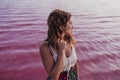 Portrait of young beautiful woman standing by a pink lake or lagoon in a natural park at sunset. Torrevieja, Spain.Tourism and Royalty Free Stock Photo