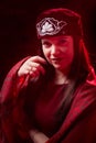 Portrait of a young beautiful woman in Tatar national folk red hat and a red dress. Fashion photo shoot in low key