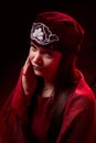 Portrait of a young beautiful woman in Tatar national folk red hat and a red dress. Fashion photo shoot in low key Royalty Free Stock Photo