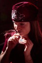 Portrait of a young beautiful woman in Tatar national folk red hat and a red dress. Fashion photo shoot in low key