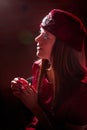 Portrait of a young beautiful woman in Tatar national folk red hat and a red dress. Fashion photo shoot in low key