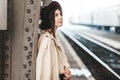 Portrait of young beautiful woman traveler who is waiting for a train on the platform of the railway station Royalty Free Stock Photo