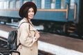 Portrait of young beautiful woman traveler who is waiting for a train on the platform of the railway station Royalty Free Stock Photo