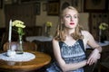Portrait of young beautiful woman in a vintage cafeteria. Suspense. Royalty Free Stock Photo