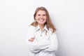 Portrait of young beautiful woman in white shirt smiling and standing with crossed arms over white background Royalty Free Stock Photo