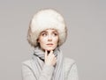 Portrait of a young and beautiful woman in a winter hat over grey background. Royalty Free Stock Photo