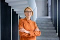 Portrait of young beautiful woman at workplace inside office, blonde business woman with crossed arms and glasses Royalty Free Stock Photo