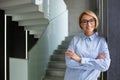 Portrait of young beautiful woman at workplace inside office, blonde business woman with crossed arms and glasses Royalty Free Stock Photo