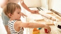 Portrait of young beautiful woman teaching her little child boy making cookies and baking pies on kitchen at home Royalty Free Stock Photo