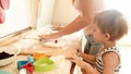 Portrait of young beautiful woman teaching her little child boy making cookies and baking pies on kitchen at home Royalty Free Stock Photo