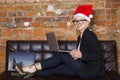 Portrait of a young beauty business woman using laptop at office before new year with santa hat. Business concept. Royalty Free Stock Photo
