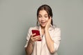 Portrait of young beautyful happy excited woman with phone. Surprised female model with smartphone Royalty Free Stock Photo