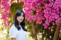 Happy beautiful young woman near blossom tree in garden.