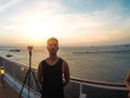 Portrait of a young black male tourist on the deck of a cruise ship in front of a sunset sky. African tourist on the beach trip Royalty Free Stock Photo