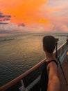 Portrait of a young black male tourist on the deck of a cruise ship in front of a sunset sky. African tourist on the beach trip Royalty Free Stock Photo