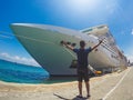Portrait of a young black male tourist in front of a cruise ship on cloudy sky. African tourist on the beach trip Royalty Free Stock Photo