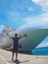 Portrait of a young black male tourist in front of a cruise ship on cloudy sky. African tourist on the beach trip Royalty Free Stock Photo