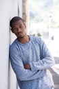 Portrait of young black man leaning against wall Royalty Free Stock Photo