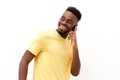 Young black man smiling and talking on mobile phone against white background Royalty Free Stock Photo