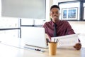 Portrait of a young black man using a laptop in a working environment, either an African businessman or a student