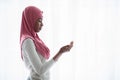 Portrait of young black muslim woman praying near window at home Royalty Free Stock Photo