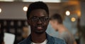 Portrait of young black smiling successful businessman wearing stylish glasses standing in modern office. Close up. Royalty Free Stock Photo
