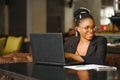 Portrait of a young black woman smiling and using laptop Royalty Free Stock Photo