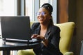 Portrait of a young black woman smiling and using laptop Royalty Free Stock Photo