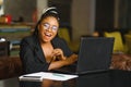 Portrait of a young black woman smiling and using laptop Royalty Free Stock Photo