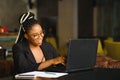 Portrait of a young black woman smiling and using laptop Royalty Free Stock Photo