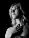 Portrait of a young blond woman with beautiful curling hair and professional make-up. black and white on a dark Royalty Free Stock Photo